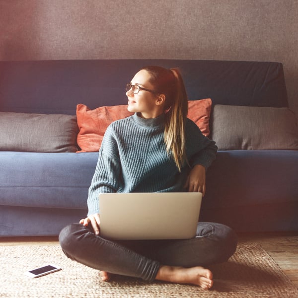 Henkilö istuu tietokone sylissä